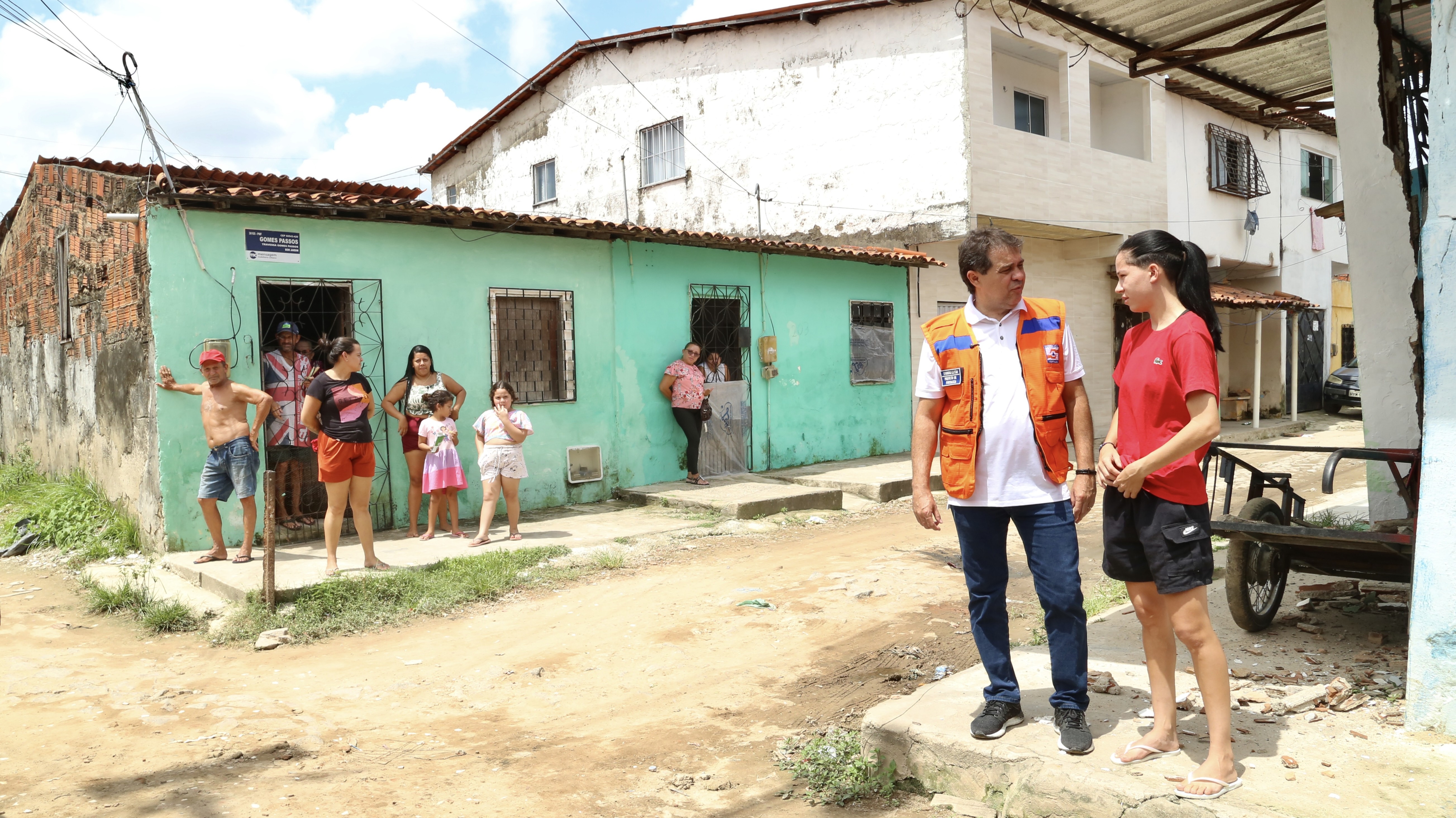 prefeito conversa com uma mulher em rua de periferia